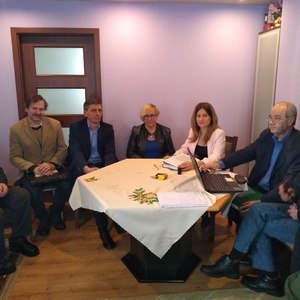 Zdjęcie uczestników spotkania siedzących przy stole.